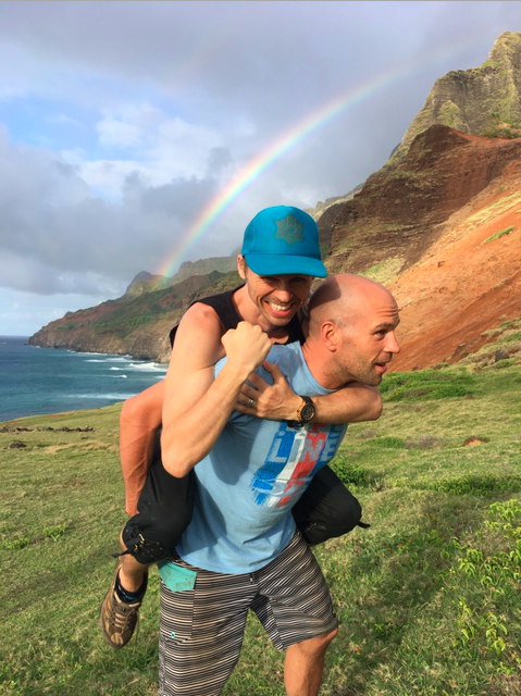 One man riding Peter Santenello in front of the rainbow in Kauai